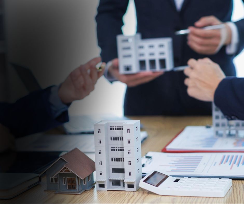Property Acquisition Guidance, consultants reviewing building models with financial charts and a calculator on a desk